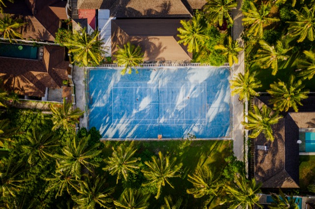 Kort tenisowy wśród palm, widok z drona